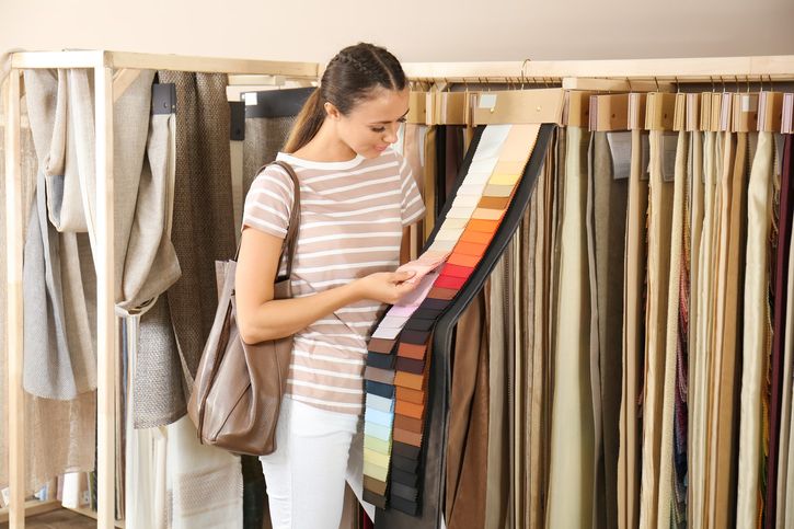 A woman choosing a different fabric for her home